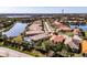 Aerial view of a lakeside community featuring terracotta roofs and lush landscaping at 4822 Grand Banks Dr, Wimauma, FL 33598