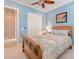Cozy blue bedroom with a ceiling fan, shutters, and a closet at 4822 Grand Banks Dr, Wimauma, FL 33598