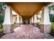 Welcoming entrance way with stone pillars leading to glass double doors and tropical landscaping at 4822 Grand Banks Dr, Wimauma, FL 33598