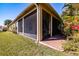 View of screened-in lanai showing brick flooring and neutral color scheme of exterior at 4822 Grand Banks Dr, Wimauma, FL 33598