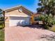 Charming single Gathering home featuring a two car garage, a brick driveway and mature landscaping at 4822 Grand Banks Dr, Wimauma, FL 33598