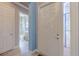 Hallway with tile floors, doors and blue walls, leading to a bathroom at 4822 Grand Banks Dr, Wimauma, FL 33598