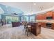 Open concept kitchen and living room features a center island with seating, stainless steel appliances, and tile flooring at 4822 Grand Banks Dr, Wimauma, FL 33598