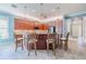 Stylish kitchen island with wood cabinets, bar stool seating and modern pendant lighting at 4822 Grand Banks Dr, Wimauma, FL 33598