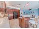 Open-concept kitchen features an island with seating, stainless steel appliances, and spacious countertops at 4822 Grand Banks Dr, Wimauma, FL 33598