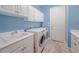 Convenient laundry room with modern washer and dryer, ample storage and sink at 4822 Grand Banks Dr, Wimauma, FL 33598