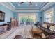 Comfortable living room with large windows and a view of the backyard patio, and wood-style tile flooring at 4822 Grand Banks Dr, Wimauma, FL 33598