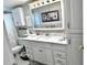 Bright bathroom with white cabinets, marble countertops, and a decorative mirror at 5108 Brittany S Dr # 204, St Petersburg, FL 33715