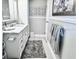Well-lit bathroom featuring white cabinetry, marble countertop, and decorative wall art at 5108 Brittany S Dr # 204, St Petersburg, FL 33715