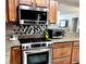 Updated kitchen featuring stainless steel appliances, granite countertops, wood cabinets and decorative backsplash at 5108 Brittany S Dr # 204, St Petersburg, FL 33715