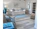 Cozy living room with a white sofa, blue accents, wood-look floors, and plenty of natural light at 5108 Brittany S Dr # 204, St Petersburg, FL 33715