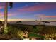 Landscaped backyard with lush greenery leading to a tranquil water view at sunset at 705 Riviera Dunes Way, Palmetto, FL 34221