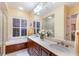 Bright bathroom with double vanity, soaking tub, shuttered window, and lots of natural light at 705 Riviera Dunes Way, Palmetto, FL 34221