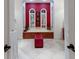 Elegant bathroom with modern fixtures, red accent wall, and large soaking tub with shuttered windows at 705 Riviera Dunes Way, Palmetto, FL 34221