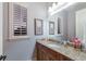 Charming bathroom with granite countertop, flamingo art and decor, and a window with shutter providing natural light at 705 Riviera Dunes Way, Palmetto, FL 34221
