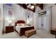 Comfortable bedroom boasts exposed beam ceiling, ensuite bathroom, and french doors at 705 Riviera Dunes Way, Palmetto, FL 34221