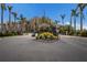 Gated community entrance, featuring lush landscaping and a stately building, creating an exclusive and welcoming environment at 705 Riviera Dunes Way, Palmetto, FL 34221