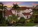 Stunning Mediterranean home with lush tropical landscaping and a beautiful tile roof at 705 Riviera Dunes Way, Palmetto, FL 34221