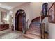 Elegant foyer featuring tile flooring, arched doorways, and a staircase with decorative iron railings at 705 Riviera Dunes Way, Palmetto, FL 34221