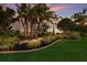 Well-manicured front yard featuring a lush lawn, mature palm trees and attractive water fountain at 705 Riviera Dunes Way, Palmetto, FL 34221