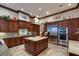 Gourmet kitchen featuring custom cabinetry, center island, and stainless steel appliances at 705 Riviera Dunes Way, Palmetto, FL 34221