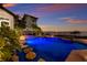 An inviting pool with led lighting, featuring a beautiful water view and rock accents at 705 Riviera Dunes Way, Palmetto, FL 34221