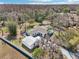 Aerial view of the home and its landscaped yard, also showing the pool and nearby wooded area at 8376 Sycamore Dr, New Port Richey, FL 34654