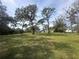 Expansive backyard featuring a lush lawn and mature trees providing ample shade and privacy at 8376 Sycamore Dr, New Port Richey, FL 34654