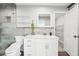 Modern bathroom featuring white vanity, quartz countertop, glass shelves, and tiled shower at 8376 Sycamore Dr, New Port Richey, FL 34654