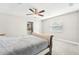 Well-lit bedroom features a plush bed, ceiling fan, and window for natural light at 8376 Sycamore Dr, New Port Richey, FL 34654