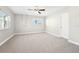 Bedroom featuring neutral carpet, two windows, and one door at 8376 Sycamore Dr, New Port Richey, FL 34654