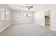 Bright bedroom with neutral carpet, ceiling fan, and walk-in closet at 8376 Sycamore Dr, New Port Richey, FL 34654