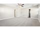 Open bedroom area with gray carpet and paint, two doors, and a window at 8376 Sycamore Dr, New Port Richey, FL 34654