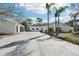 Wide driveway leading to a well-maintained home and garage, complemented by palm trees and lush landscaping at 8376 Sycamore Dr, New Port Richey, FL 34654