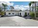 Charming single-story home with a spacious driveway and lush landscaping, including mature palm trees at 8376 Sycamore Dr, New Port Richey, FL 34654