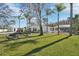 Landscaped home exterior showcasing a well-manicured lawn and mature palm trees in a bright, sunny setting at 8376 Sycamore Dr, New Port Richey, FL 34654