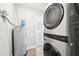 Modern laundry room features stacked washer and dryer, plus water heater at 8376 Sycamore Dr, New Port Richey, FL 34654