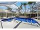 Screened-in pool area with a blue pool and a clear view of the surrounding trees at 8376 Sycamore Dr, New Port Richey, FL 34654