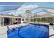 Screened-in pool area with picnic table and comfortable lounge chairs at 8376 Sycamore Dr, New Port Richey, FL 34654