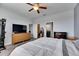 The spacious main bedroom includes a ceiling fan, wood flooring and ensuite at 10019 Celtic Ash Dr, Ruskin, FL 33573