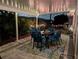 Inviting covered patio with outdoor dining set, blue cushioned chairs, and string lights for evening relaxation at 10142 44Th N Way, Pinellas Park, FL 33782