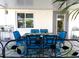 Outdoor dining area featuring a blue cushioned dining set on a brick patio with adjacent potted plants at 10142 44Th N Way, Pinellas Park, FL 33782