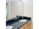 Modern bathroom with granite counters, double sinks, and a large mirror at 10346 Carrollwood Ln # 171, Tampa, FL 33618