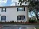 Exterior view of a condo with blue shutters, landscaping and parking at 10346 Carrollwood Ln # 171, Tampa, FL 33618
