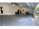 Spacious garage with epoxy floors, refrigerator, garage door and utility connections at 11713 Summer Springs Dr, Riverview, FL 33579