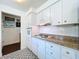 Kitchen featuring white cabinetry, granite countertops, and decorative tile flooring at 1282 Palm St, Clearwater, FL 33755