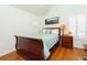 Cozy bedroom features a sleigh bed, wood floors, and a bright window with plantation shutters at 18934 Avenue Biarritz, Lutz, FL 33558