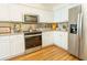 Well-lit kitchen features stainless steel appliances, ample white cabinetry, and sleek backsplash at 18934 Avenue Biarritz, Lutz, FL 33558