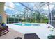 Screened-in pool area with clear blue water surrounded by a spacious deck and lush landscaping at 18934 Avenue Biarritz, Lutz, FL 33558