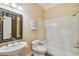 Charming bathroom with decorative mirror, pedestal sink, white tiled shower and tub at 2508 W Shell Point Rd, Tampa, FL 33611